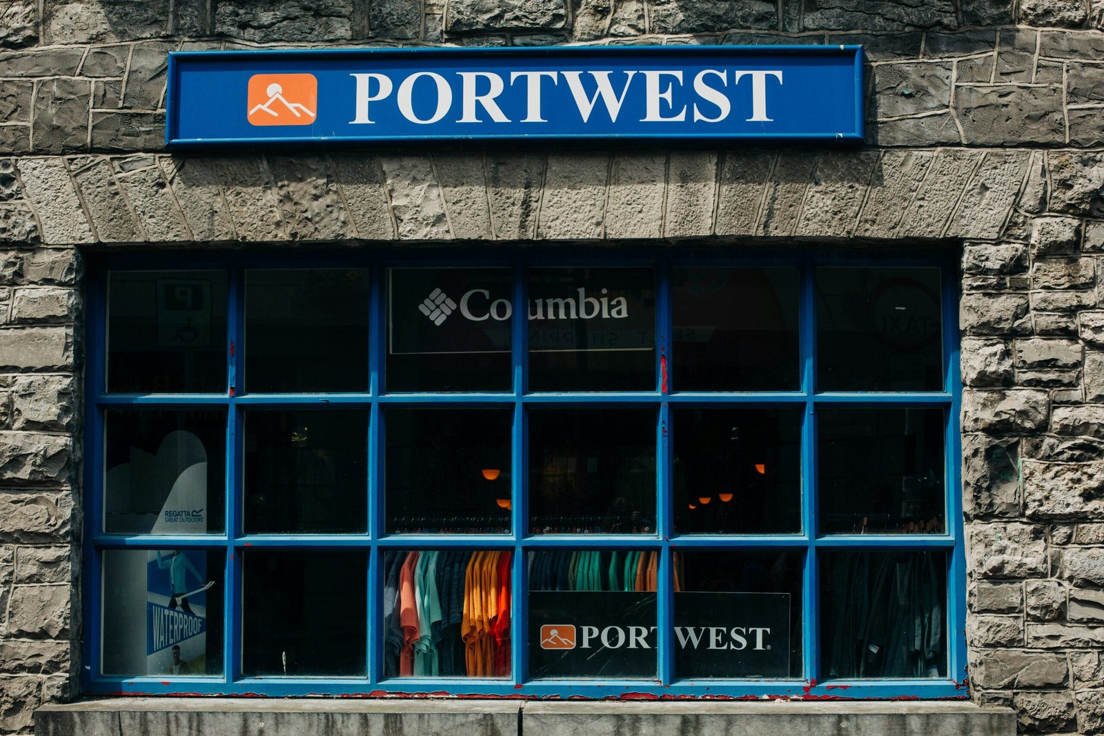 a store front with a blue window and a surfboard in the window